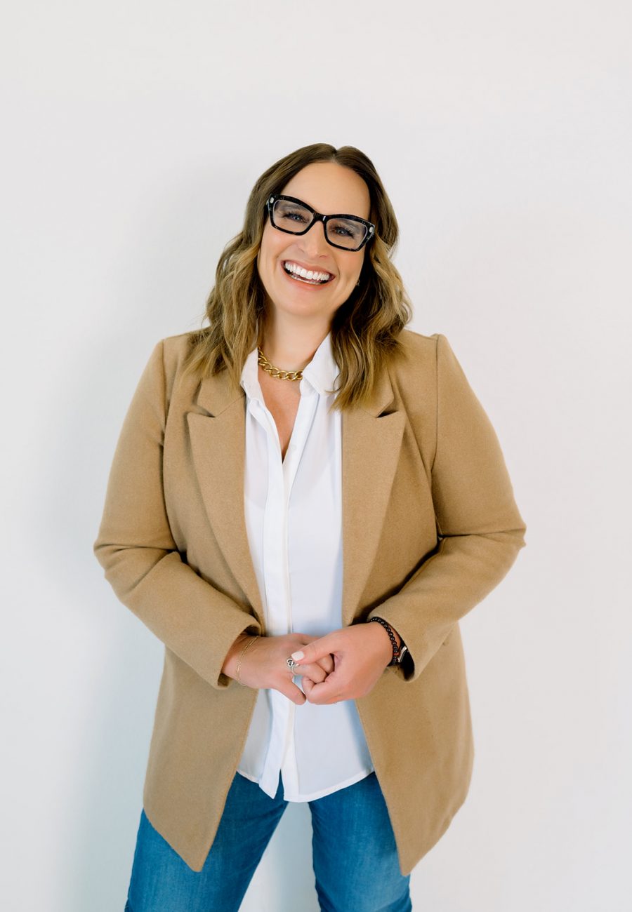 Life coach in blazer against plain background posing for brand photos